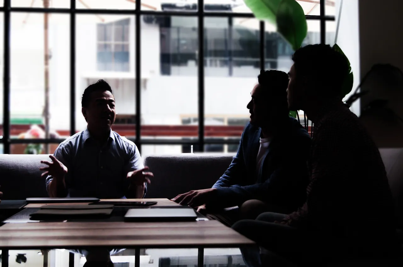 Three colleagues having an informal conversation in a modern office