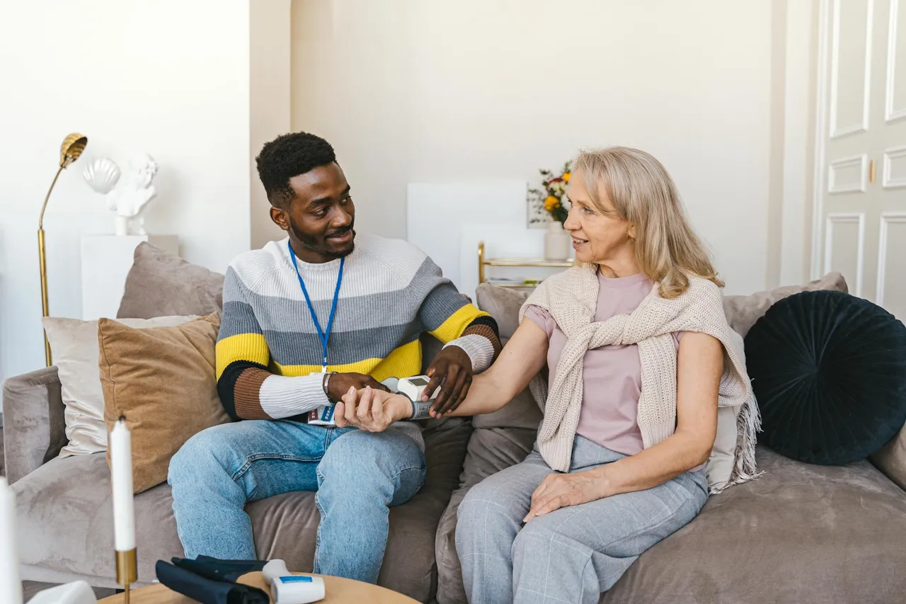 Caregiver smiling with a senior client by a window